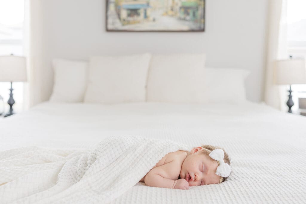 Timeless photo of a newborn asleep on a white bed