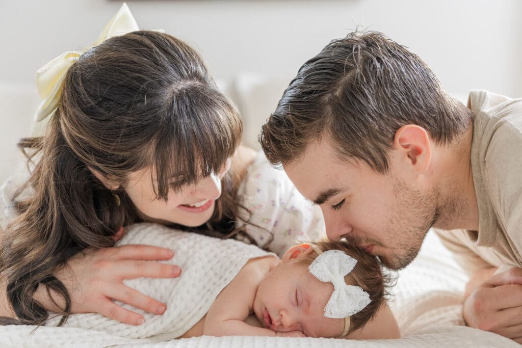 Dad kissing his newborn during an in-home session in Boise