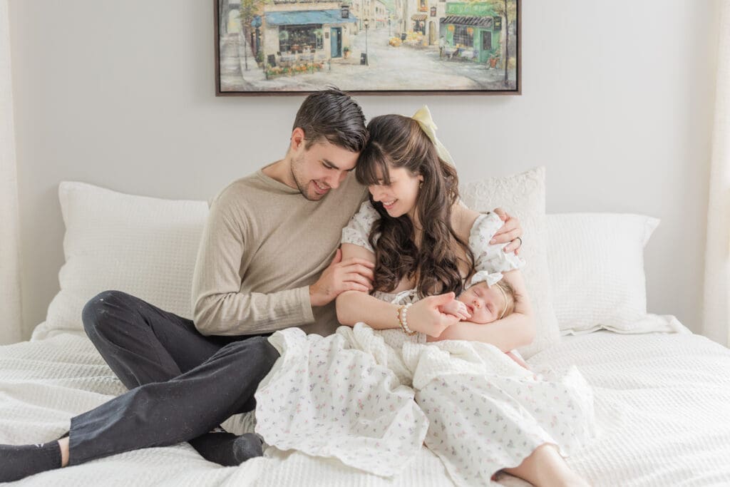 Parents cuddling their newborn baby during an in-home session in Boise