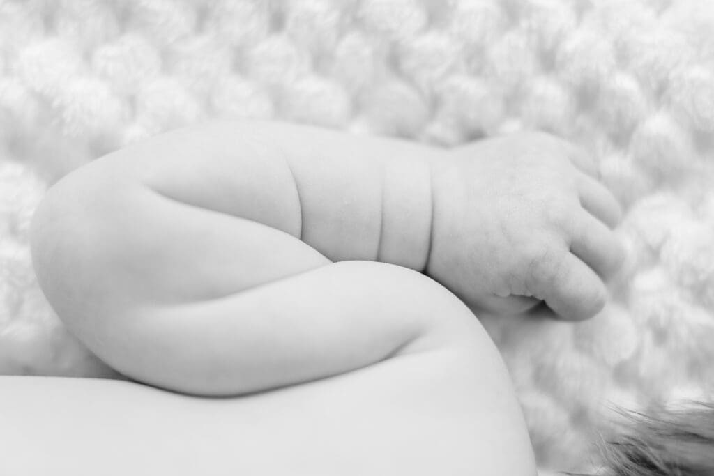 Curled sleeping newborn on soft blanket during Nampa newborn photography session