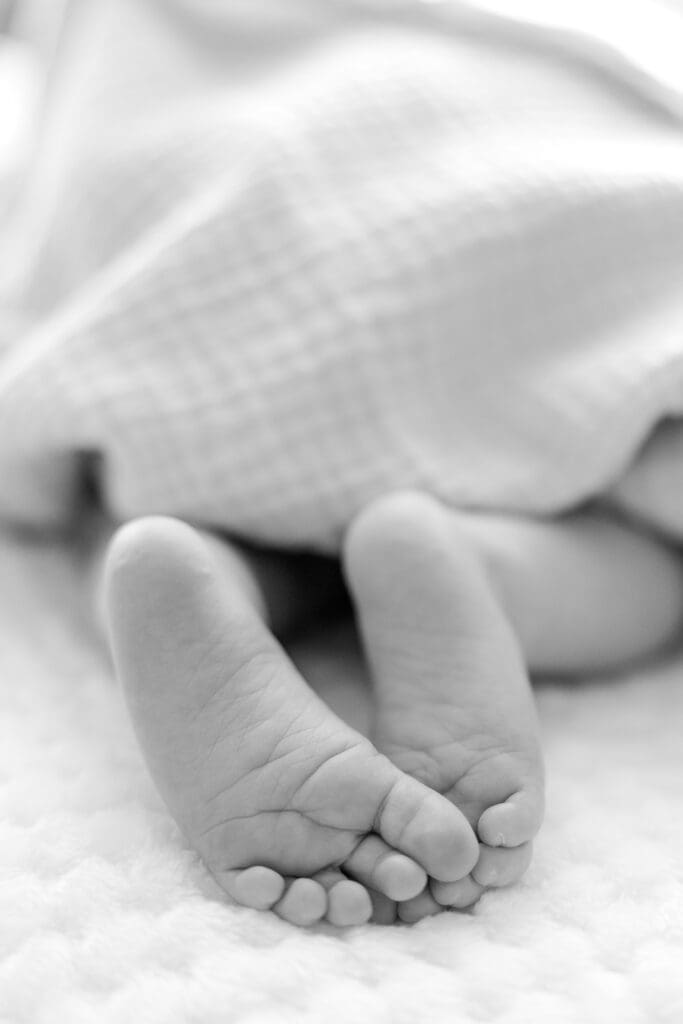 Close-up of newborn feet and toes on a soft textured blanket