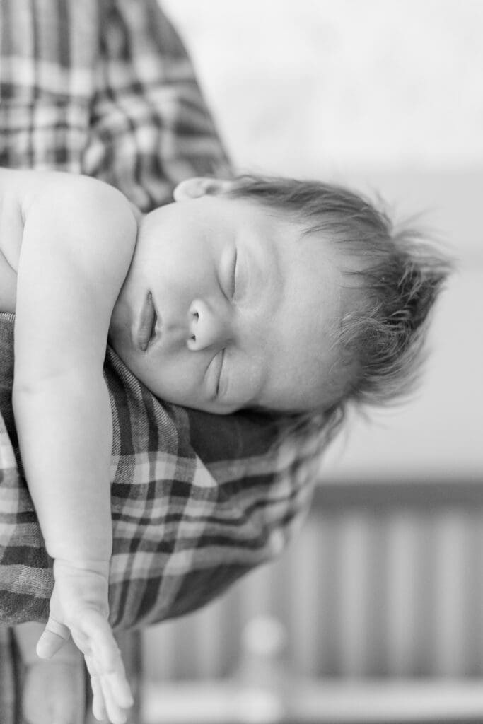 Sleeping newborn resting on dad during Nampa newborn photography session