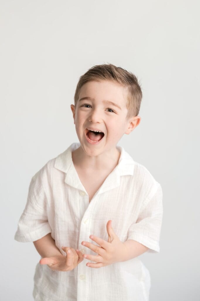 Close-up portrait of smiling young boy during studio family session