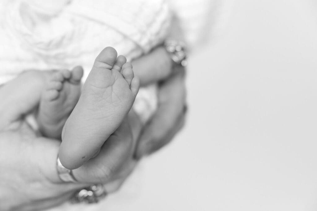 Black and white detail photo of tiny newborn feet during baby session