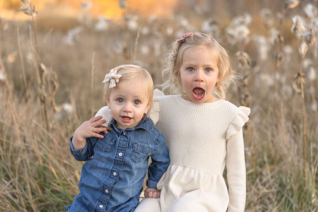 Sisters sharing a playful moment during an outdoor family photo session